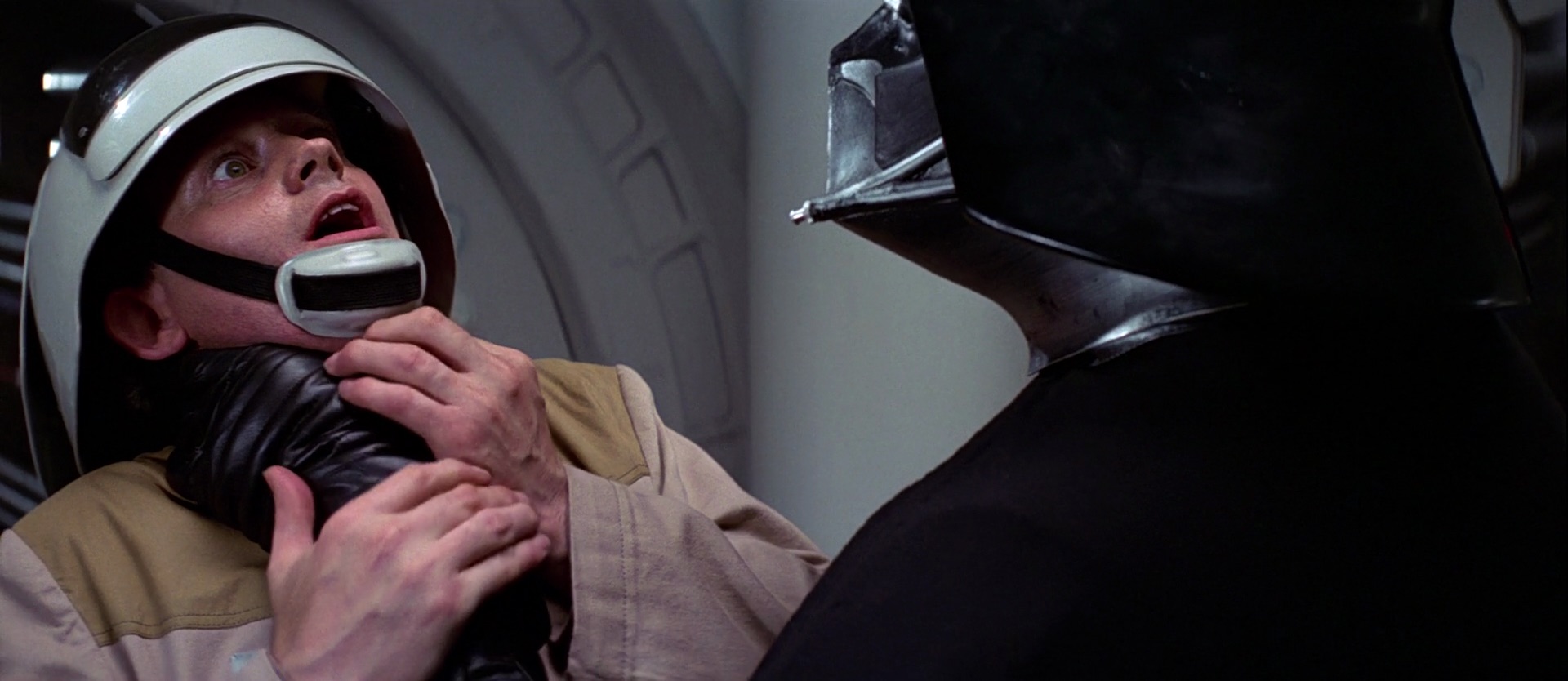 A still from Star Wars (1977) showing Darth Vader strangling the heck out of a Rebel officer with his left hand.