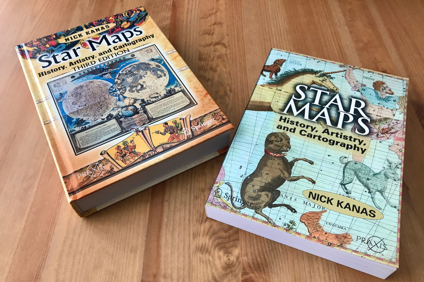 Two copies of Nick Kanas's Star Maps on a wooden table, the third edition at left and the first edition at right